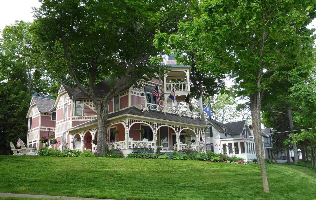 Victorian summer cottage with a gingerbread-trimmed wraparound porch and shade trees in Bay View