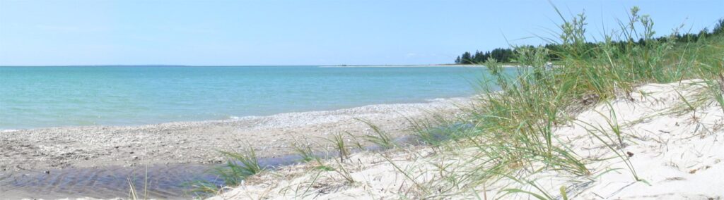 Wide sandy beach and turquoise water at Iron Ore Bay on the south shore of Beaver Island