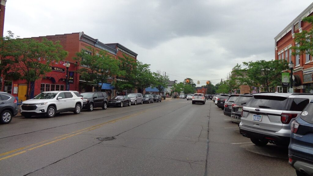 Water Street in Boyne City, a small downtown of brick storefronts with trees and parked cars