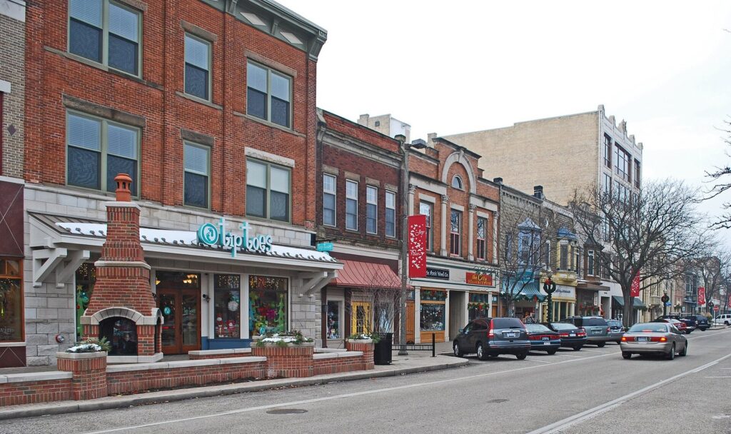 Row of restored brick storefronts along 8th Street with holiday decorations and parked cars
