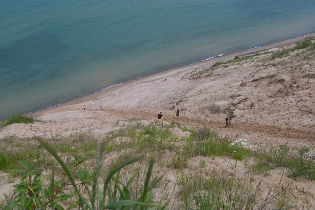 Steep sand slope of the Grand Sable Banks dropping to Lake Superior, with small figures climbing back up