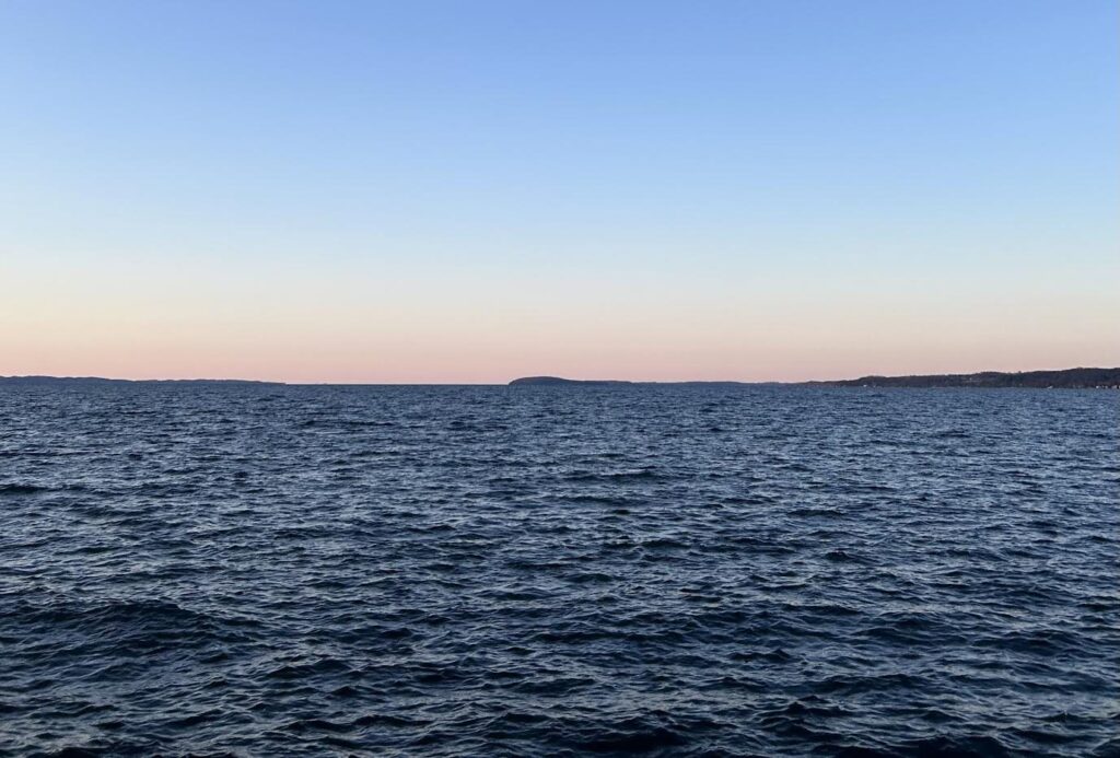 Grand Traverse Bay at dusk seen from the Clinch Park marina, calm water under a pink sky