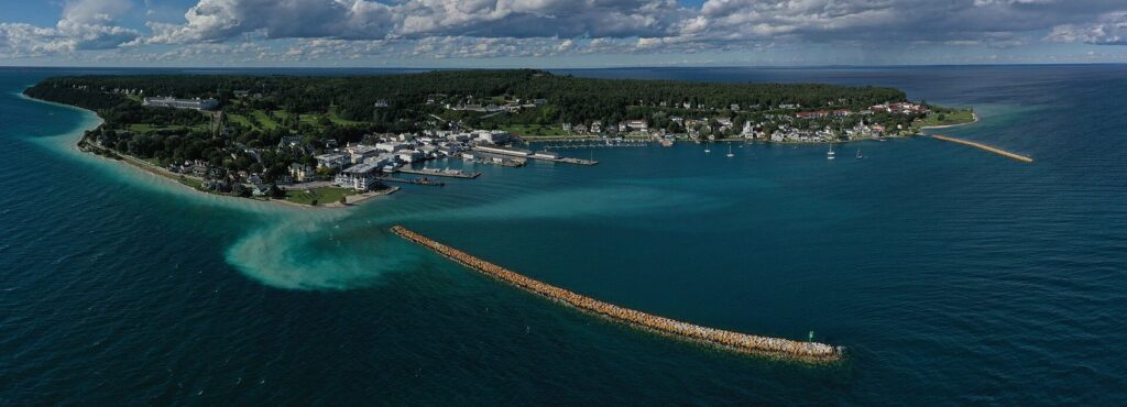 Aerial view of the island's south shore with the harbor breakwaters, downtown and wooded interior